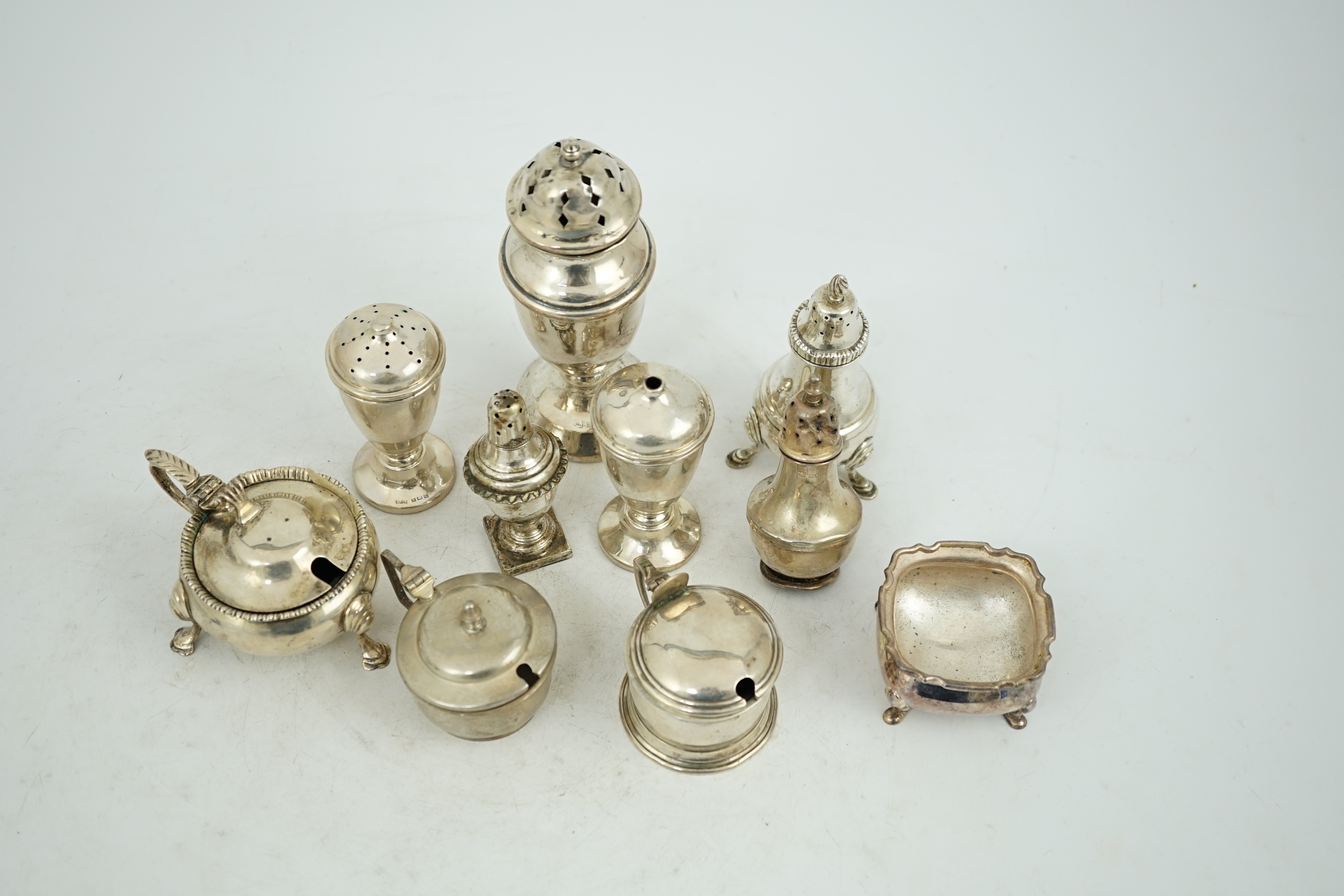 Nine assorted early 20th century and later silver condiments, various dates and makers and one plated condiment.